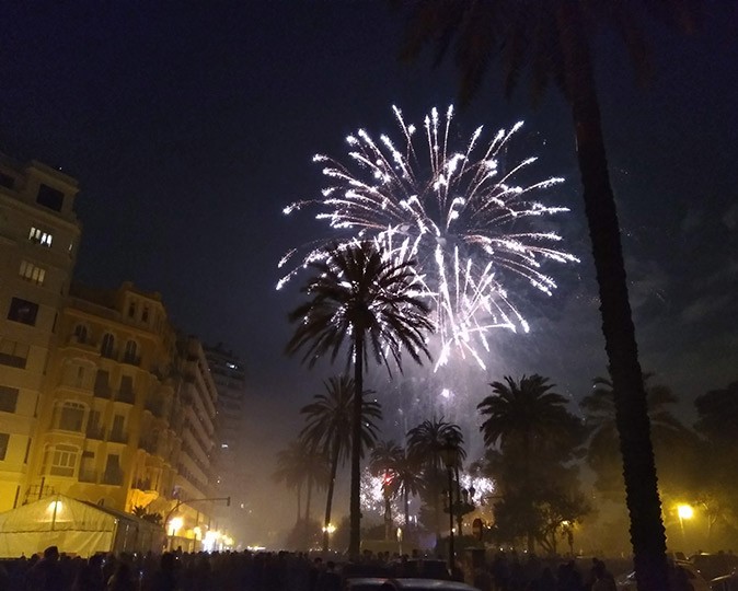 fireworks in Spain White fireworks surrounded by palm trees and city buildings
