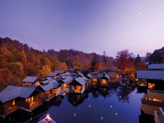A luxury retreat in Japan A luxury hotel retreat with bungalows around a lake with a purple sunset