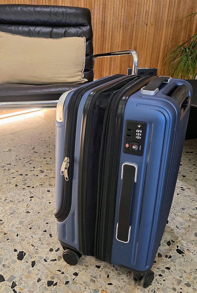 One of the best suitcases for frequent travelers A blue and black suitcase on the floor in front of a black leather chair