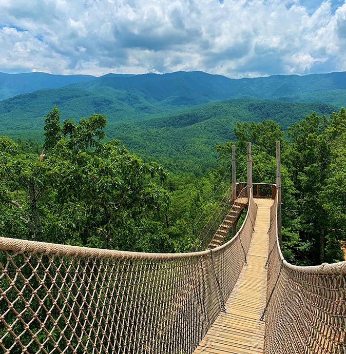 One of Gatlinburg's attractions A roap bridge surrounded by greenery and with green mountains in the background