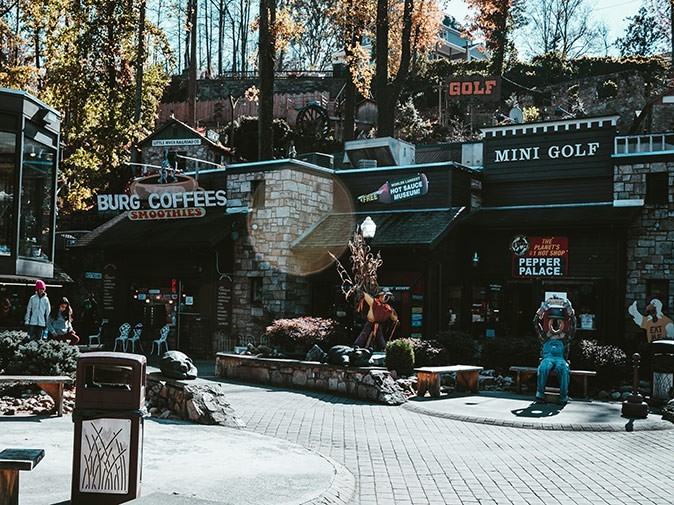 An urban scene with a coffee shop and an entrance to a place to play mini golf