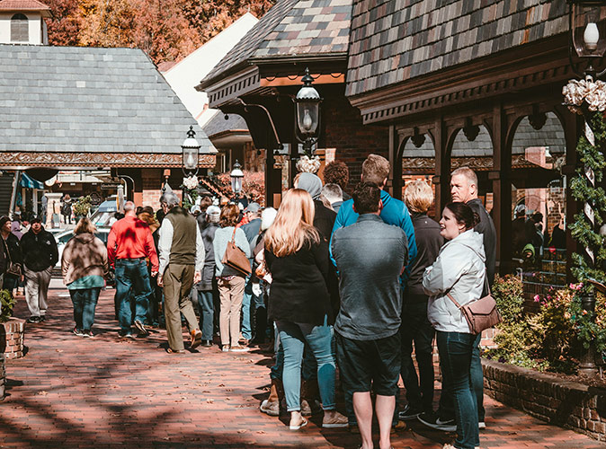 Tips for visiting Gatlinburg A queue of people in a town center with gray and brown buildings