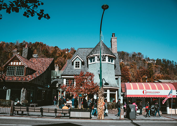Visiting Gatlinburg An urban setting showing several buildings in gray, brown and red, a sidewalk and part of a road