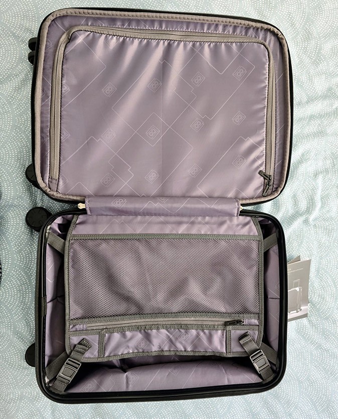 How to find the best hand luggage An opened suitcase showing a gray interior on a white and mint green bed