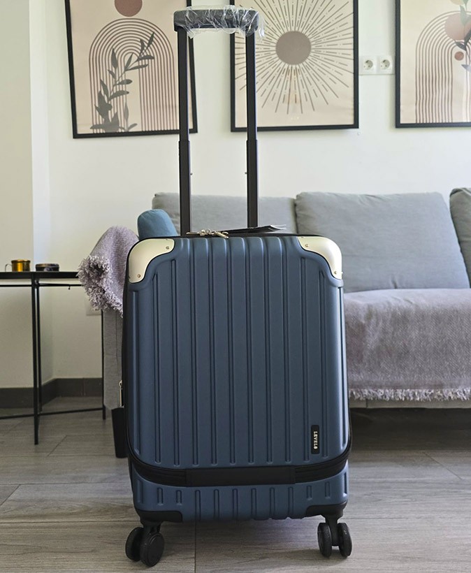 How to pick the right carry-on suitcase A blue and black suitcase standing in front of a gray couch