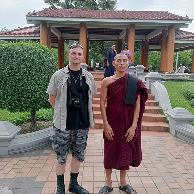 Expat life in Yangon A white male standing next to a Buddhist monk in a red robe inside a park