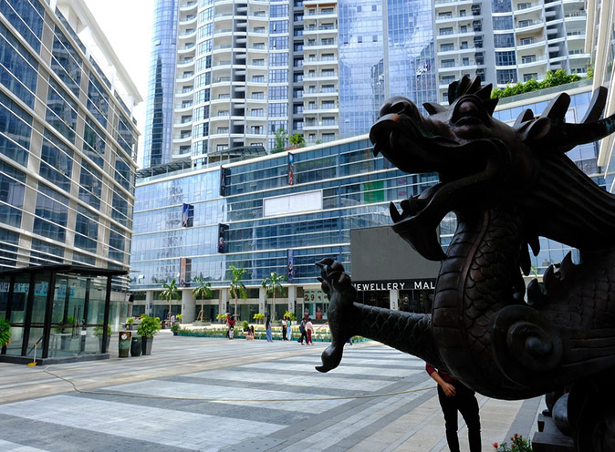 Expat life in Yangon, Myanmar A moders square showing the bottom parts of modern highrise buildings and part of a statue of a dragon