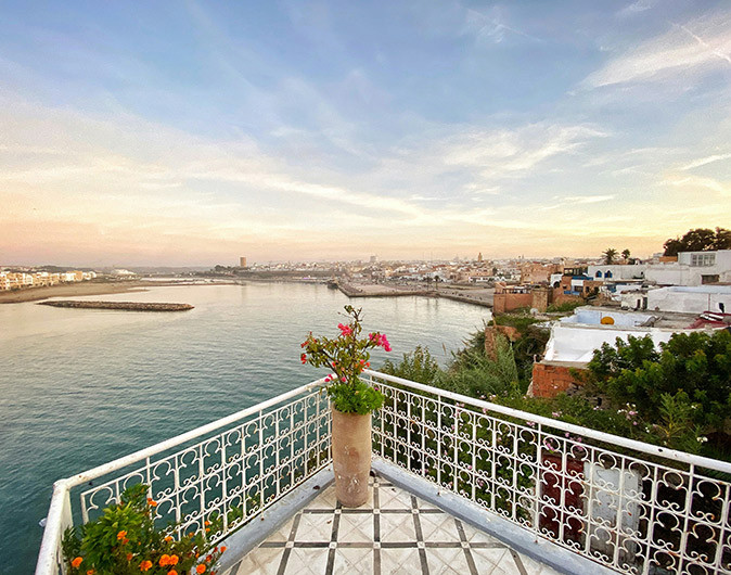 Living in Rabat, Morocco Part of a terrace with a white fence overlooking a bay with white and brown buildings
