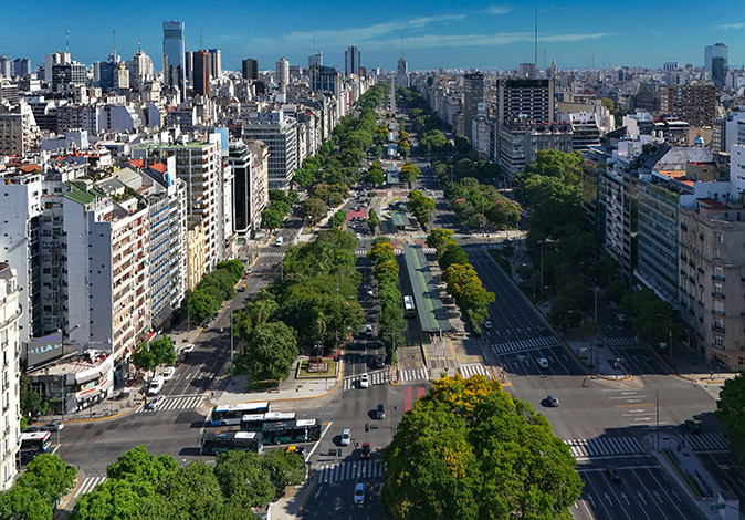 Local tips for living in Buenos Aires Aerial view of a wide road with greenery and some cars, with high rise buildings on both sides