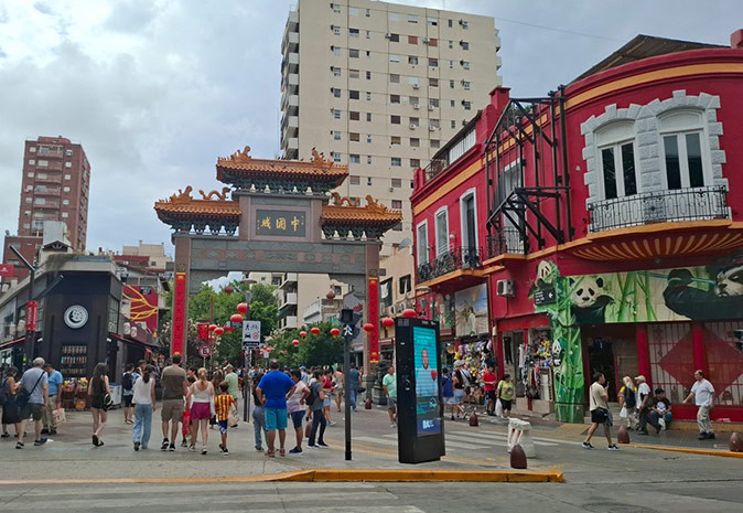 Tips for living in Buenos Aires A typical Chinese gate marking the entrance to Chinatown in Buenos Aires with several people walking and red and beige buildings on the side