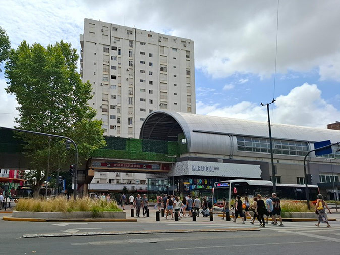 Public transport in Buenos Aires A modern looking train station with a bus in front of it and several pedestrians