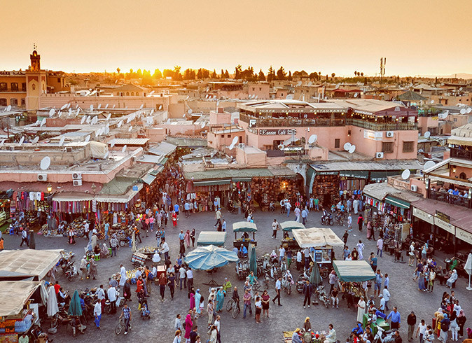 Life in Marrakesh, Morocco Aerial view of a market with several small stands and a lot of people, set in a city. Picture taken during sunset