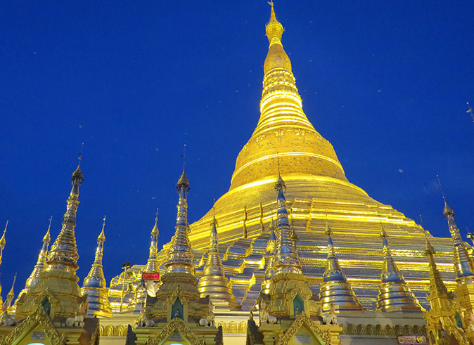 Shwedagon Pagoda, a must-visit in Yangon A large, gold pagoda with a bright blue sky