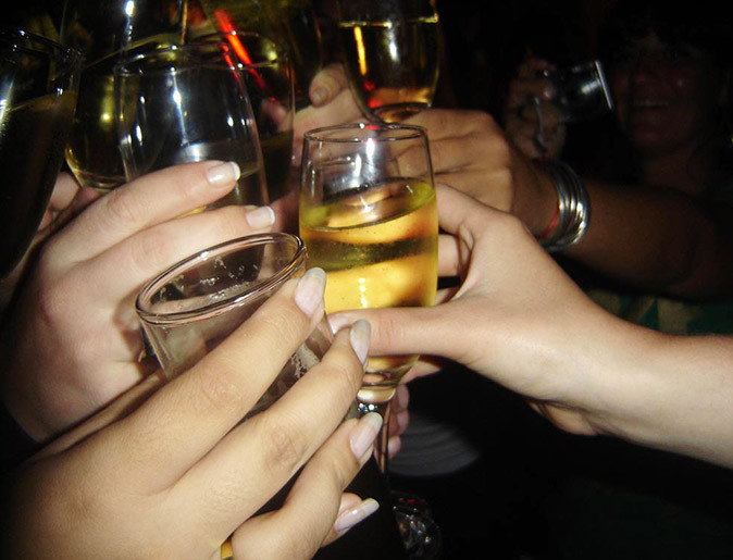 Nightlife in Buenos Aires - tips from a local Several hands hoding drinks in a dimly lit bar