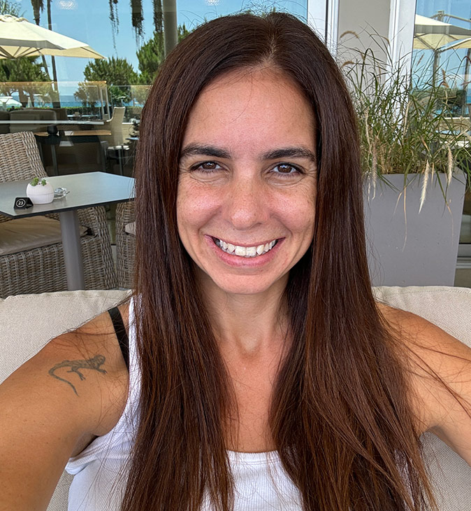 An expat living in Cyprus Headshot of a woman with long brown hair, smiling at the camera