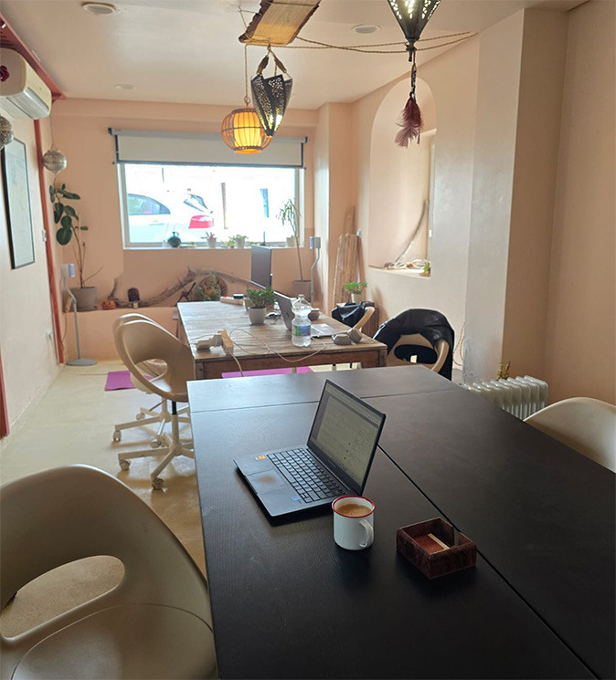 A coworking space in Tarifa, Andalusia, Spain A coworking space with 2 long tables, several chairs, one laptop and a coffee
