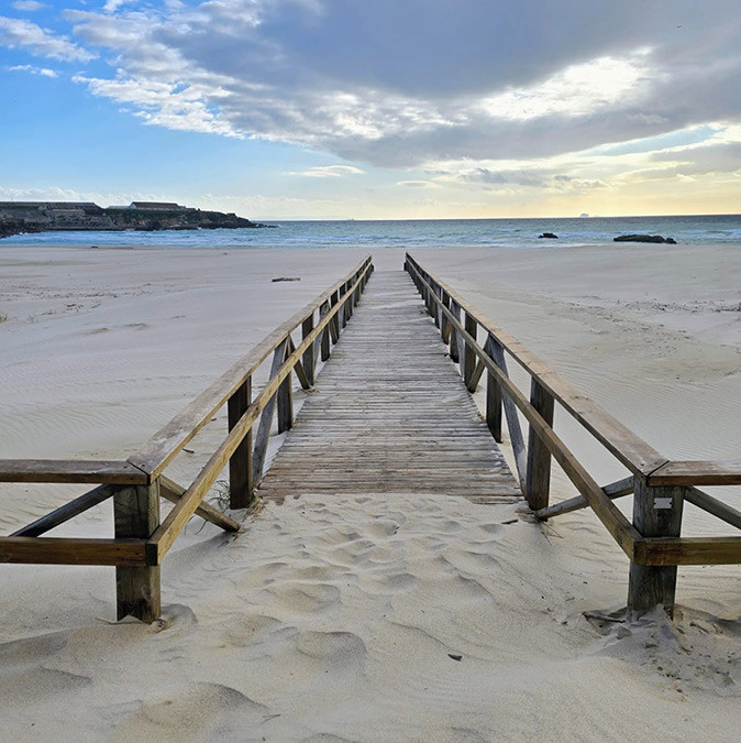 Tarifa beach A wooden walkway leading to a sandy beach with the sea in the background