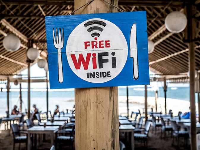 Tips for using internet abroad A blue and white sign saying "free wifi inside" with a restaurant in the background