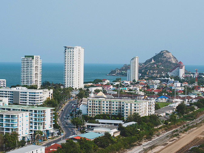 Hua Hin, a town worth visiting in Thailand Aerial picture of a coastal city showing a main road, highrise buildings and a hill plus sea in the background
