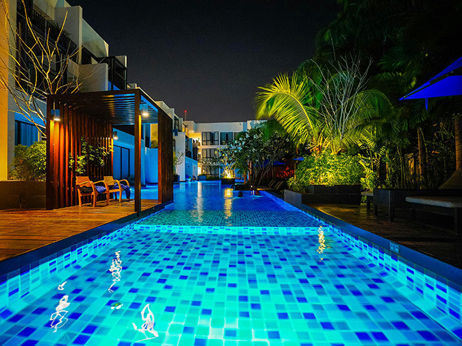 Where to stay in Hua Hin, Thailand A large swimming pool at night plus part of a hotel building