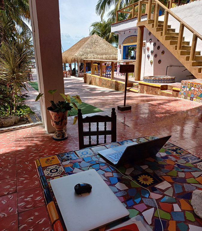 Safely using public wifi 2 laptops on a table with a tropical colorful background including palmtrees