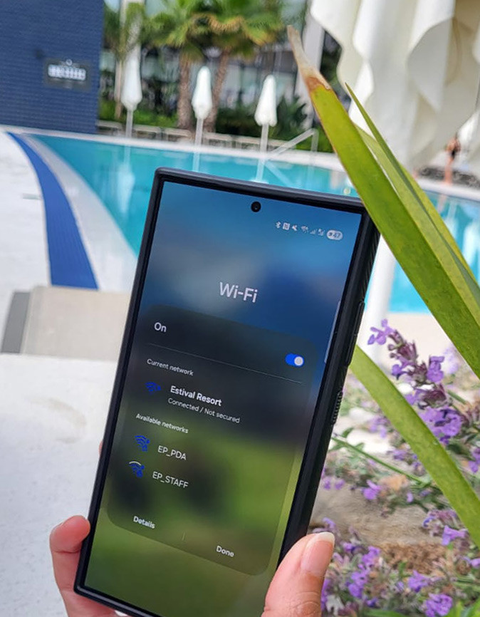 Using unsecured wifi at a hotel A laptop in a hand showing an unsecured hotel wifi network with a swimming pool in the background