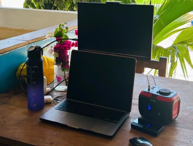 A laptop with an extra screen on a wooden restaurant table