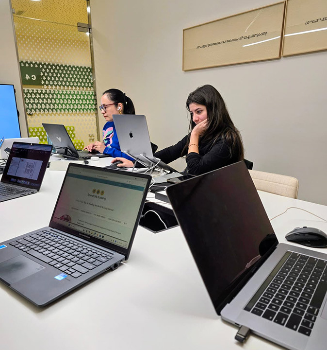 Working from a coworking space in Valencia 5 laptops in an office with 2 people visible behind their laptops