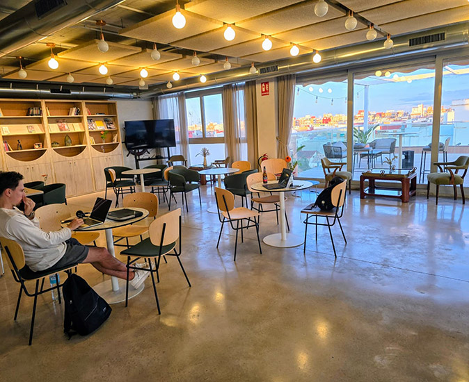 A coworking space in Valencia A coworking space in Valencia with several tables and chairs, 2 laptops and one man working