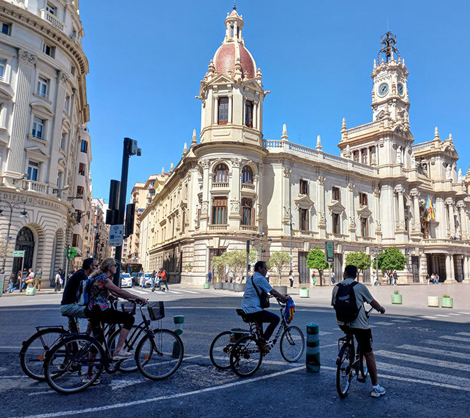 Cycling in Valencia as a digital nomad 4 cyclist at a crossing with historical Spanish buildings in the background