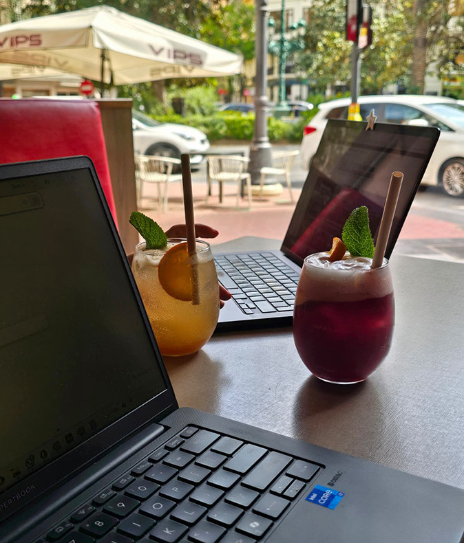 Working from a cafe in Valencia 2 laptops and 2 cocktails on a table in a cafe in Valencia