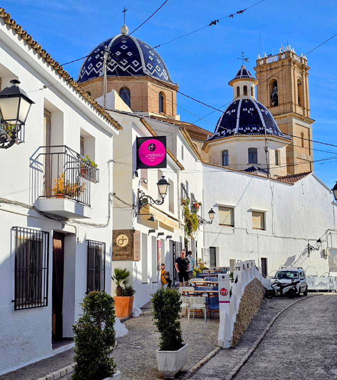 A weekend trip to Altea from Valencia Whitewashed houses on a narrow street with a blue domed church in the background