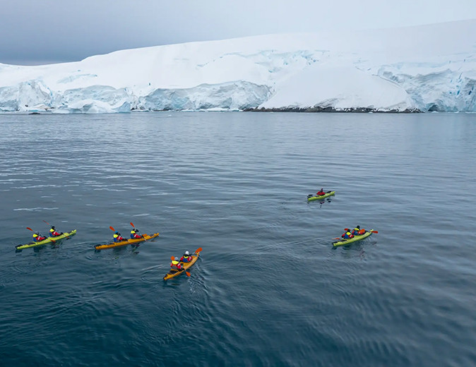 Kayaking during the Ross Sea expedition A group of people in kayaks surrounded by ice shelfs in the Ross Sea
