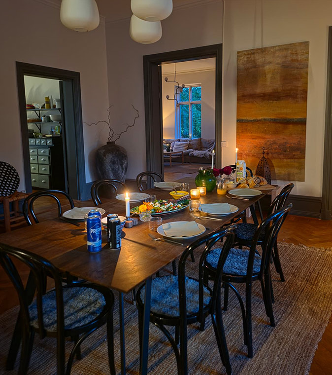A cozy coliving house in Sweden A nicely set table for 6 in a cozy room with art on the wall
