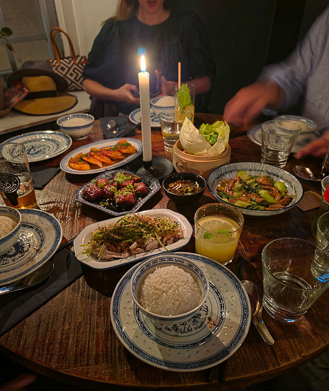A communal dinner during the coworking retreat in Sweden A restaurant table filled with small plates of Asian food and a candle