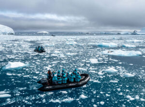 A zodiac filled with people surrounded by water and ice in the Ross Sea