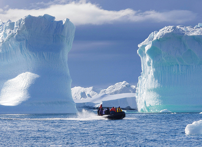 The unique cruise experience to the Ross Sea A zodiac going through huge walls of ice in Antarctica