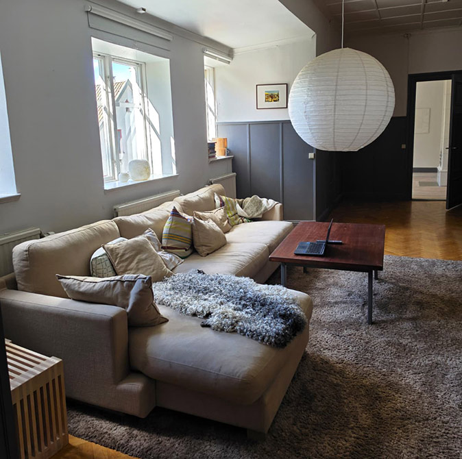 Working from Sweden on a workation A comfortable beige sofa with a laptop on a wooden table